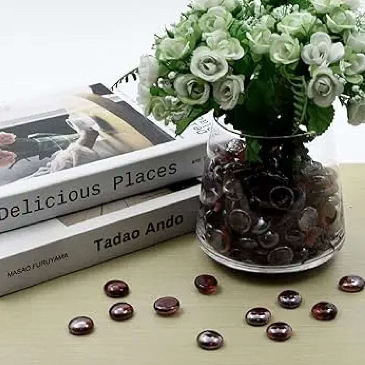 ST0NED 15kg grey glass pebbles in a clear vase with white flowers on a table next to stacked books SGI Online