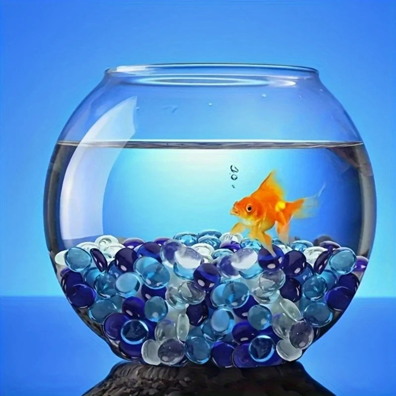 Goldfish swimming in a fishbowl filled with decorative glass pebbles clear and blue by STONED SGI Online