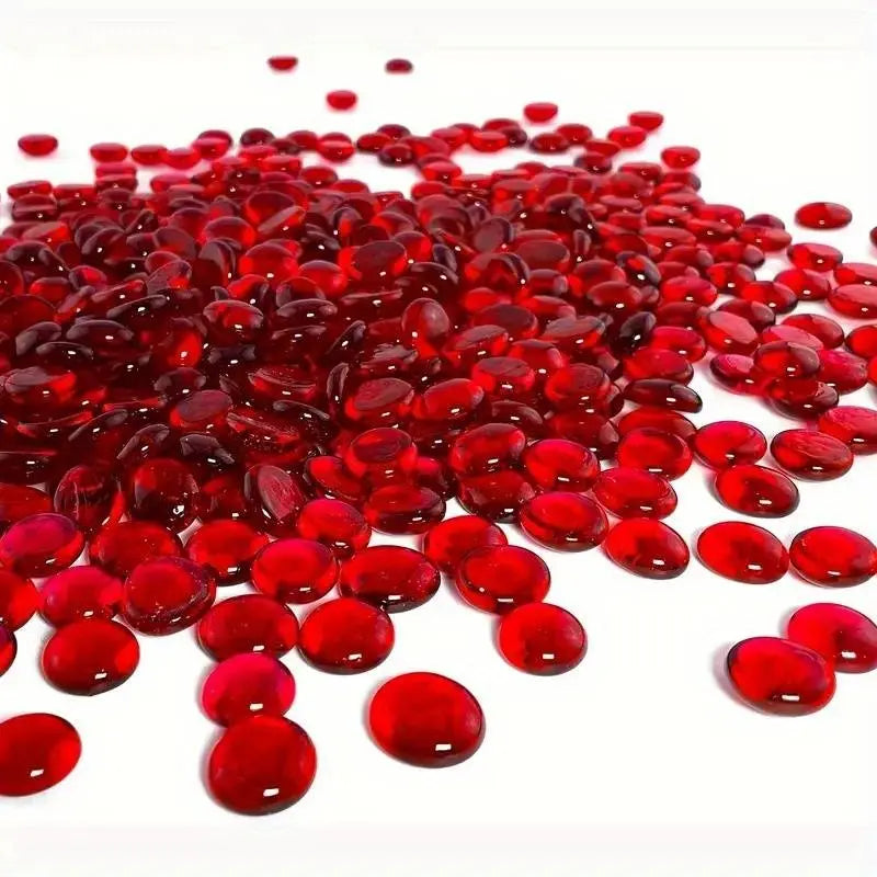 Shiny red glass pebbles scattered on white surface from STONED glass pebbles collection