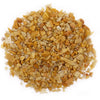 Pile of polished golden quartz gemstone chips in various shades of yellow and gold