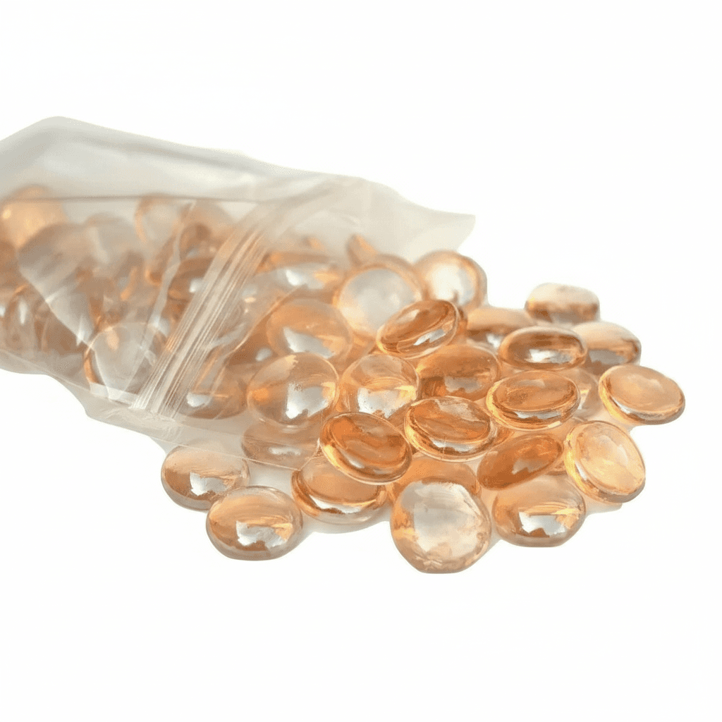 STONED peach glass pebbles spilling from a clear resealable bag with smooth rounded shapes