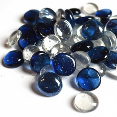Cobalt blue glass pebbles for decor mixed with clear glass stones on a white surface