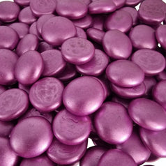 Close-up of metallic pink glass pebbles with smooth, rounded surfaces and shiny finish