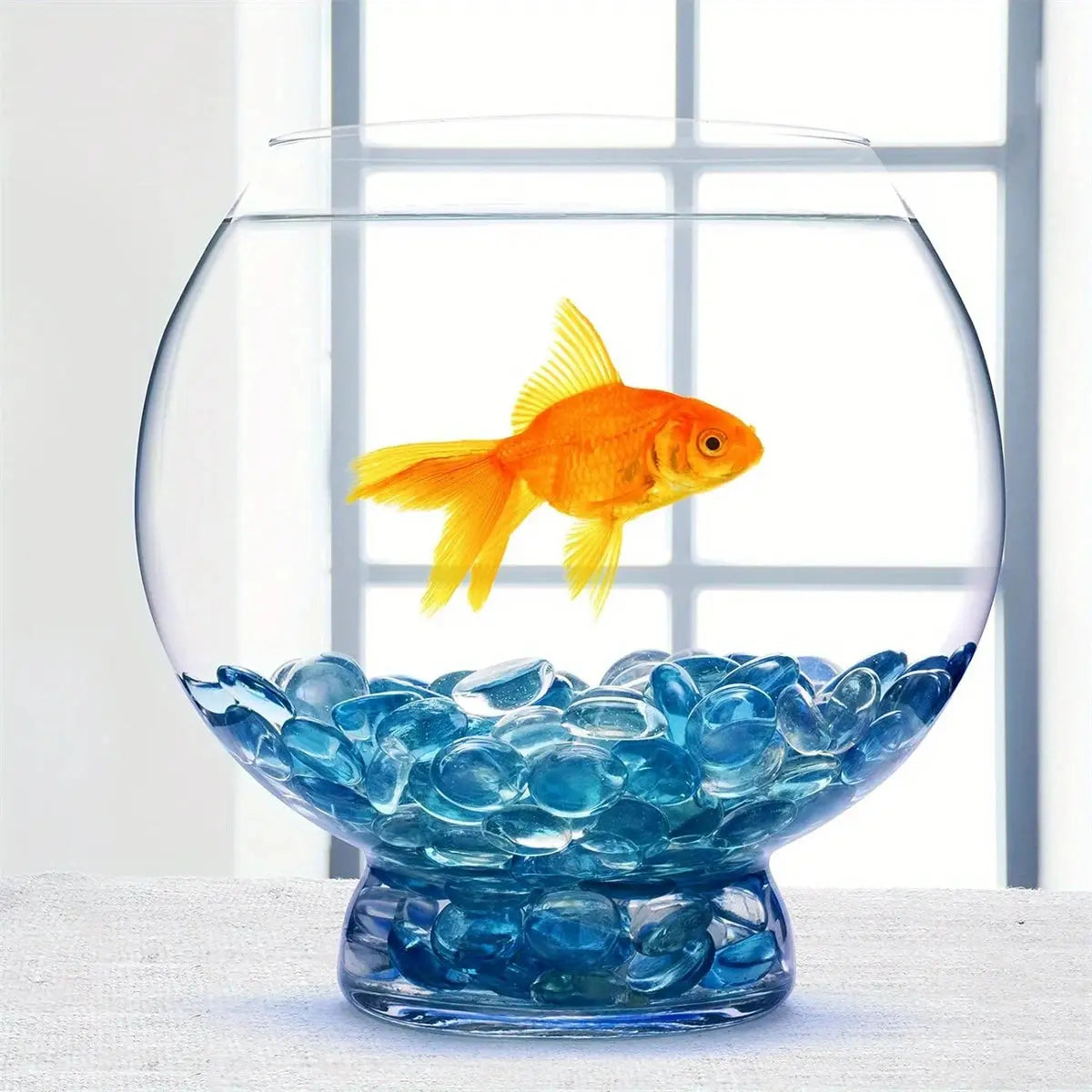 Fishbowl with a goldfish swimming above STONED turquoise glass pebbles as decorative aquarium stones SGI Online