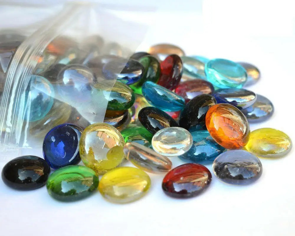 STONED mixed color glass pebbles spilling out of a clear plastic bag on a white surface SGI Online